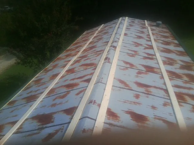 Rusted metal roof panels with new wood purlins before replacement — Storm Damage Roof Repair in Parma by Roofing Brothers