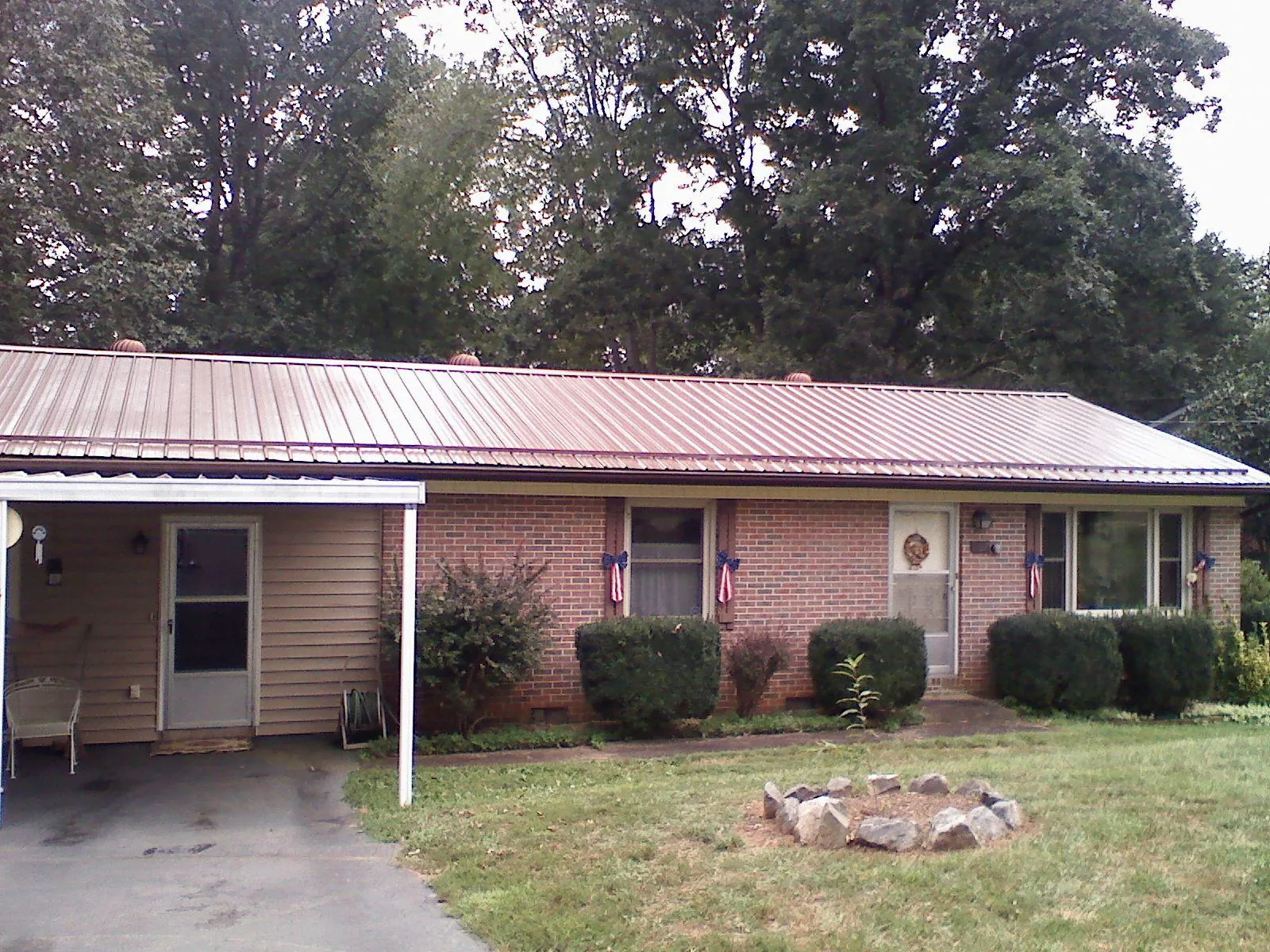 Bronze metal roof and carport on a brick ranch home — Roof Repair work by our crew in Parma